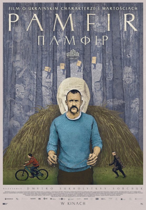 W tle siano, jeżdzące na rowerach dzieci, a na pierwszym planie mężczyzna ubrany w niebieski sweter i ciemne spodnie