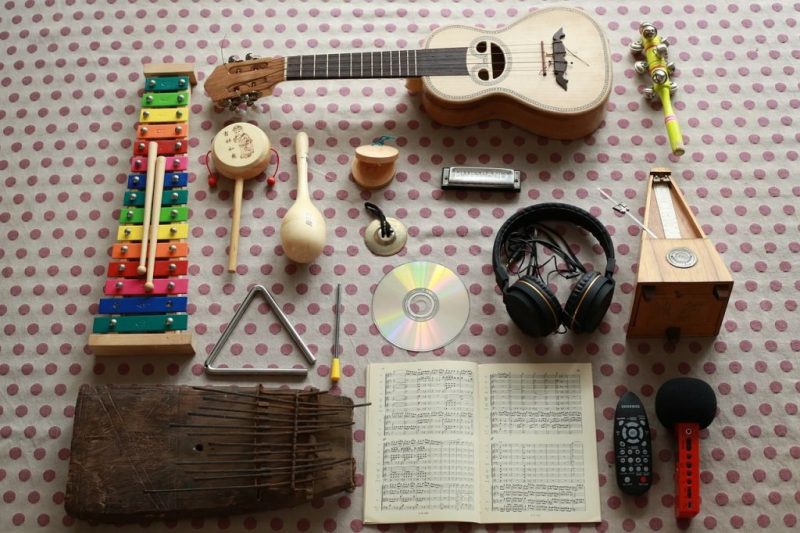 Na dywanie rozłożone instrumenty muzyczne takie jak: cymbałki, trójkąt, grzechotki, gitara