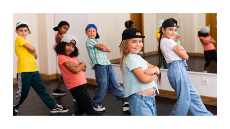 Grupa dzieci ćwiczy w sali tanecznej układ choreograficzny