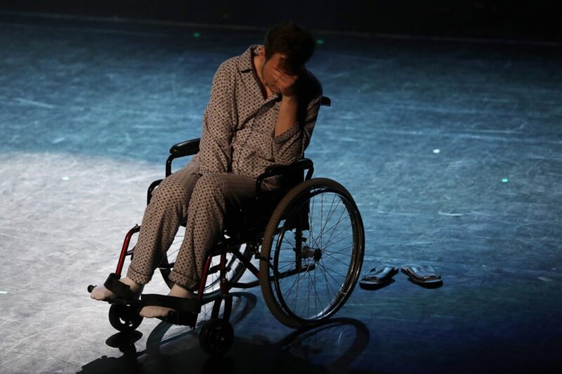załamany chłopak siedzi w piżamie na wózku inwalidzkim