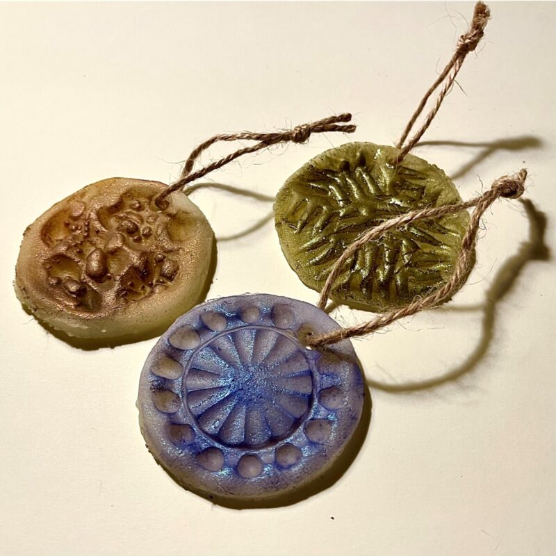 Kolorowe porcelanowe bombki w kształcie medalionów zawieszone na sznurku