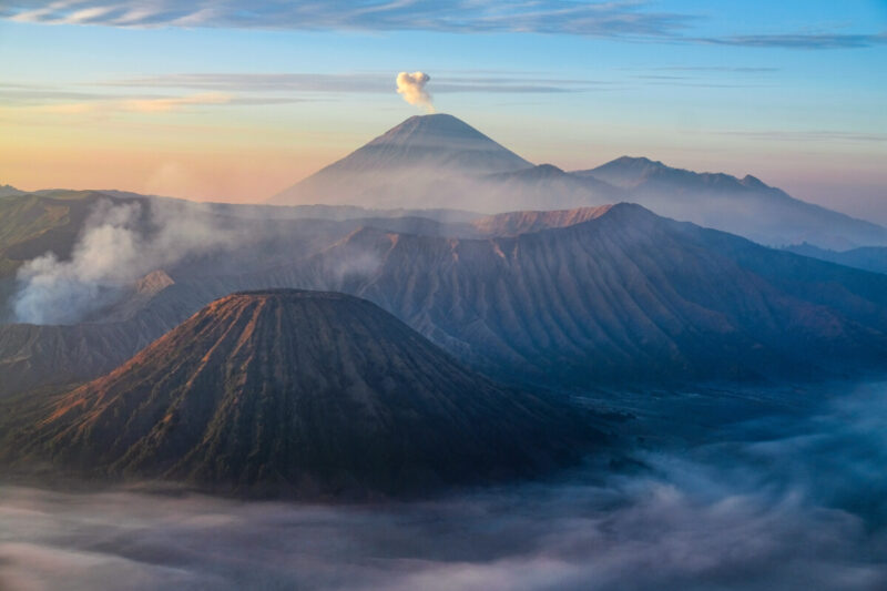 Wschód słońca z widokiem na wulkan Bromo na Jawie w Indonezji. W tle dymiący wulkan Semeru.
